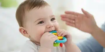 Smiling baby chewing on a teething toy, finding relief from discomfort