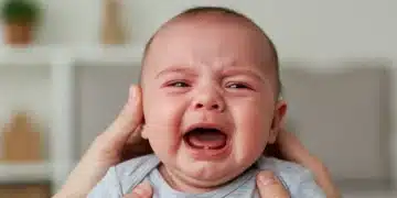 Parent comforting crying baby experiencing colic pain