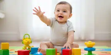 Happy baby playing with colorful blocks on a mat, stimulating early development